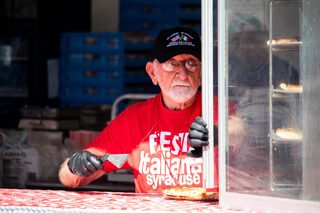 A member of the American Italian Heritage Association greets customers and serves pizza. Festa Sausage & Pizza by Twin Trees, along with a few other vendors, have been a consistent part of the Festa Italiana food scene for years.